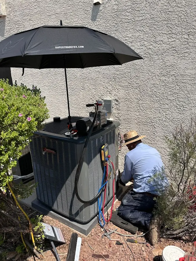 HVAC technician performing outdoor AC maintenance in Norton
